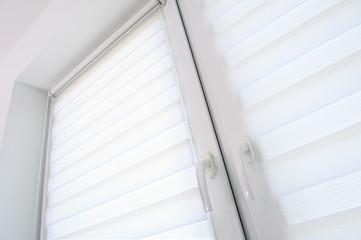 White roller blind on a metal plastic window