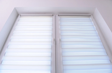 Obraz premium White roller blind on a metal plastic window