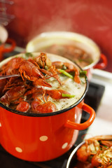 Crayfish are cooked in a large red saucepan. Cooking crayfish.