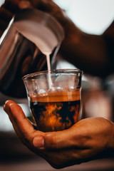 Milk being poured into coffee