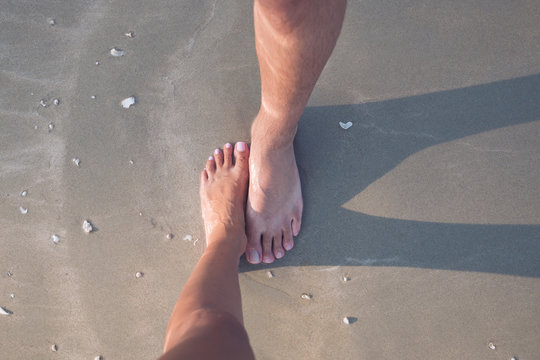 One Male And One Female Feet On The Sand