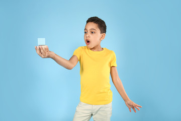 Portrait of surprised little boy with cubes on color background