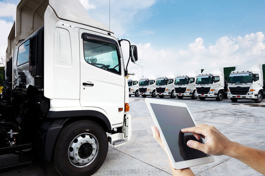 People hand is using tablet multiple photo with new truck fleet is parking on the yard for technology with transportation concept.