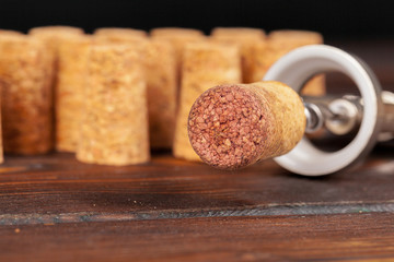 Wine corks with corkscrew on wooden table