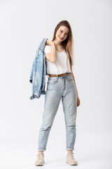 Naklejka premium Stylish young woman in jeans on white background