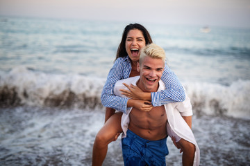 Happy young couple having fun and love at beach on sunny day