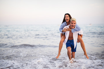 Fototapeta na wymiar Happy young couple having fun and love on the beach