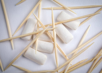 Fototapeta na wymiar Toothpicks and chewing gum on white background. Dental hygiene and health