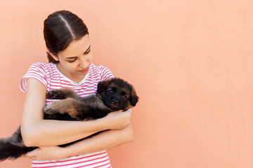 Beautiful woman in striped T-chirt holding small dog