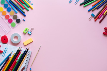 Various school accessories on pink board with copy space. Concept back to school.