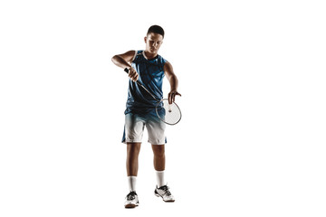 Little boy playing badminton isolated on white studio background. Young male model in sportwear and sneakers with the racket in action, motion in game. Concept of sport, movement, healthy lifestyle.