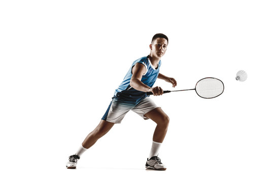 Little boy playing badminton isolated on white studio background. Young male model in sportwear and sneakers with the racket in action, motion in game. Concept of sport, movement, healthy lifestyle.