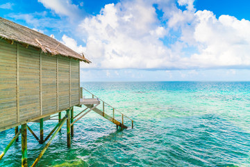 Beautiful water villas in tropical Maldives island at the sunrise time .