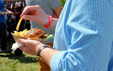 White man hand with a big burger at burger festival.