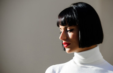 Woman mysterious with red lips makeup face defocused background close up. Fashion and beauty concept. Makeup bright accent on lips. Red lipstick makeup suits her. Perfect makeup for brunette lady