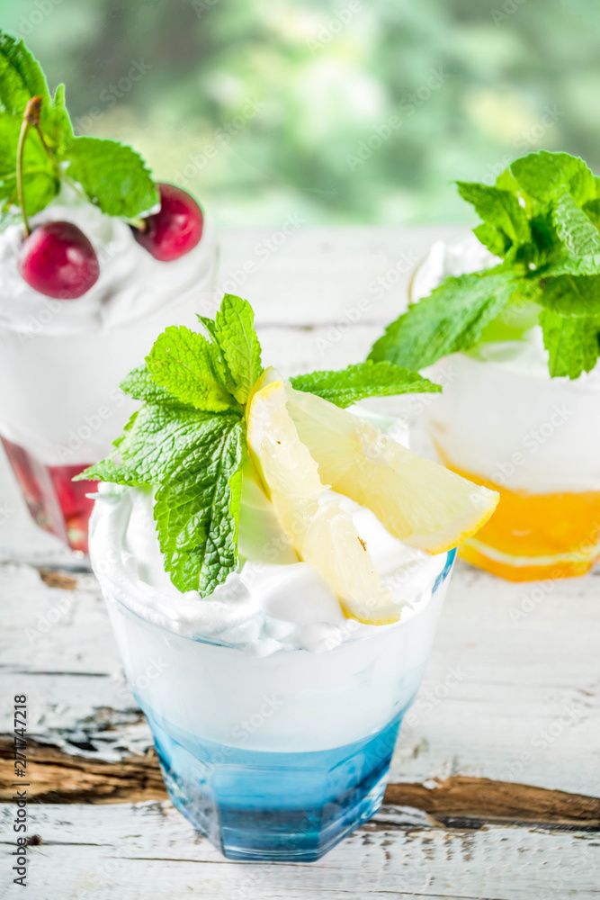 Wall mural summer cold drinks. colorful italian cream soda cocktails over white wooden background copy space