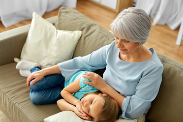 family, generation and people concept - happy smiling grandmother and granddaughter resting on...