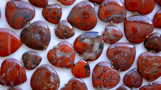 Semi-precious stone hearts of brecciated jasper are rotating in a clockwise direction top view