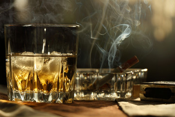 A glass of whiskey on the rocks and a Smoking cigarette
