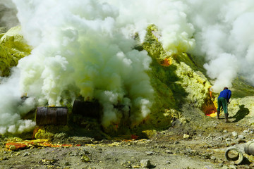 MINER COLLECTING SULFUR ON KAWAH IJEN VOLCANO IN JAVA ISLAND-INDONESIA