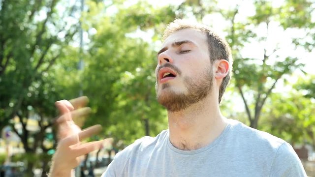 Overwhelmed man drying sweat in a hot summer day standing in a park