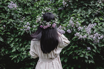 woman in white dress with lilac flower crown in garden