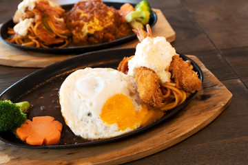 Steak with fried shrimp and Japanese style on a wooden table.