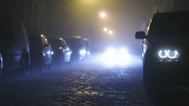 The car goes on the road with bright headlights. evening night time