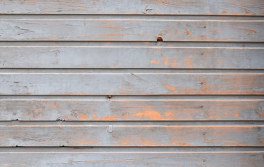 Unique texture painted with gray oil paint wooden planks of the old building with orange bright spots