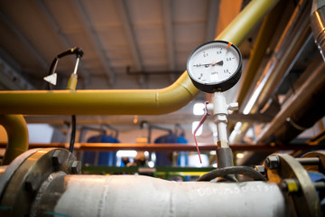 pressure gauge psi meter in pipe and valves of fire emergency system industry focus closeup middle red background