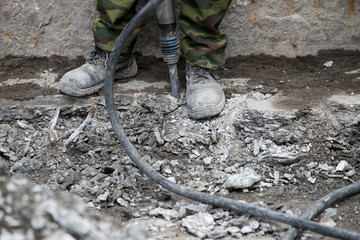 Industrial worker details. Male worker using jackhammer pneumatic drill machinery
