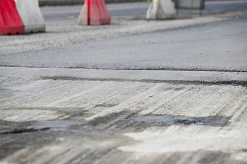 Work on road. Construction cones. Traffic cone, with white and orange stripes on asphalt. Street and traffic signs for signaling. Road maintenance, under construction sign and traffic cones on road.