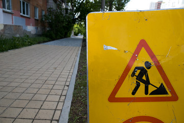 Damaged asphalt road. Repair of engineering road highways. Bad road. Detour sign on the road...
