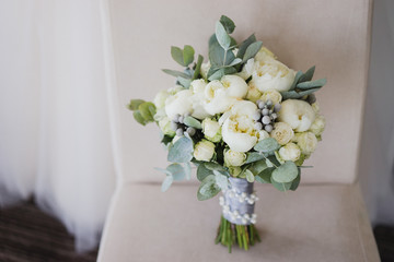 Beautiful modern bridal bouquet of colorful fresh flowers with sikl ribbons. Classic wedding traditional accessory.