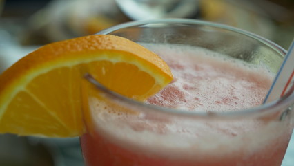 Fresh strawberry smoothie in a glass with Orange