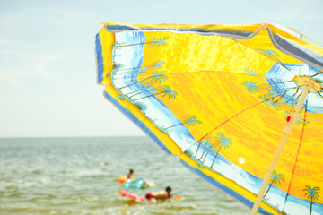 Obraz premium Bright orange sun umbrella on beach