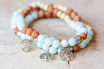 Mineral stone amazonite and tree pendant bead bracelet on natural wooden background