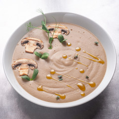 Cream soup with mushrooms, mushrooms and potatoes in a white bowl