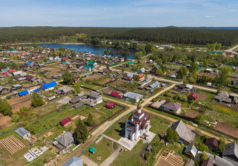 Obraz premium Church in Kamenka village surrounded by forest, Sunny day, summer, Aerial