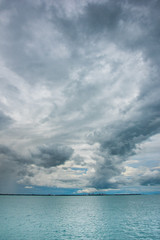 Naklejka na ściany i meble Dark tropical storm clouds POV ocean