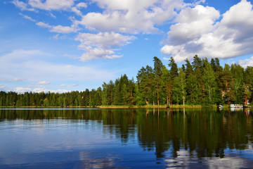 Fototapeta na wymiar Landscape with lake, blue sky, beautiful clouds and reflection in the water