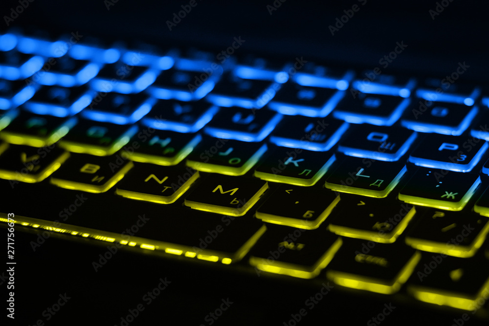 Poster beautiful colorful modern keyboard with blue and yellow backlight. backlight of the keyboard in colo