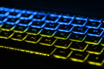 Beautiful colorful modern keyboard with blue and yellow backlight. Backlight of the keyboard in...