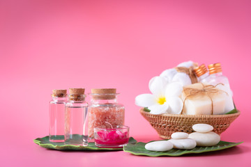 Spa  Himalayan salt,red candle,milk  and rose liquiSpa  Himalayan salt,red candle,milk  and rose liquid.soap,white towel,flowers ,zen stone set on green leaves over pink backgroundd.