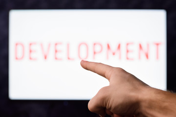 Man pointing to finger to screen with inscription DEVELOPMENT