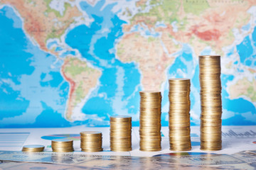 World Business Concept : Grown Up Coin Graph on World Map and US Dollars Background.