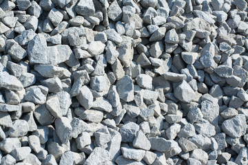 Background of crushed stone against a sun in a pile. Material for road construction