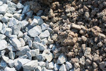 Background of crushed stone and soil against a sun in a pile. Materials for road construction