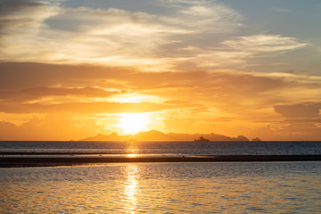 Beautiful beach sunset with blue sea and golden light sky  cloud background