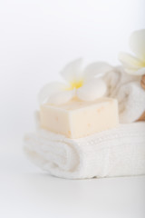 White towels,organic soap and Plumeria flower over white background,spa concept